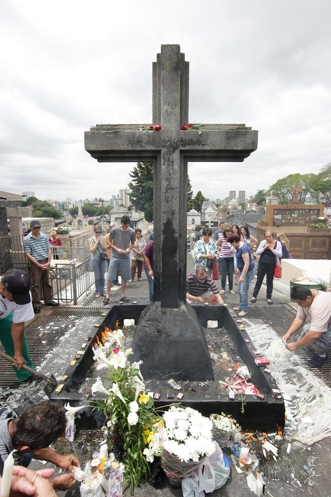 Cruz das almas no cemitério São Francisco, onde os visitantes acendem velas. | 