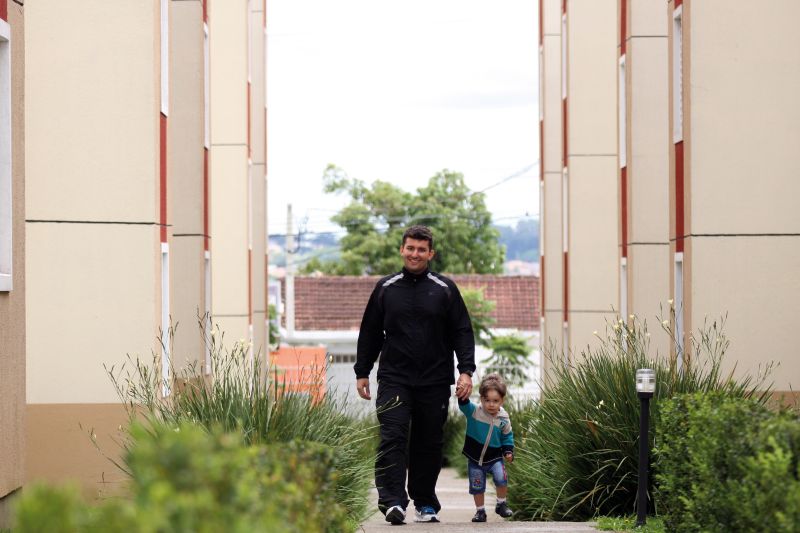 O professor de Educação Física Leandro Cunha com o filho no condomínio em que moram em São José dos Pinhais: "Aqui tenho tudo o que preciso para viver" | Fotos: Marcos Borges/Gazeta do Povo