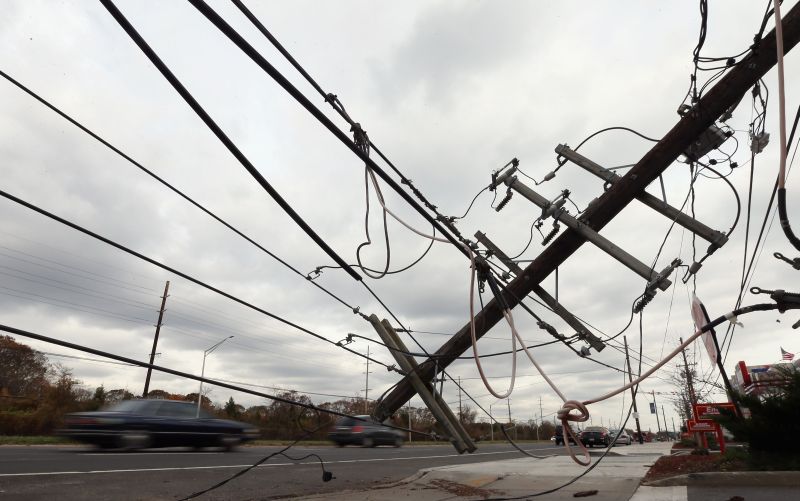 Postes e fiação caídos na Sunrise Highway no Massapequa Park, em Nova York: vestígios da passagem da tempestade Sandy | Bruce Bennett/Getty Images/AFP