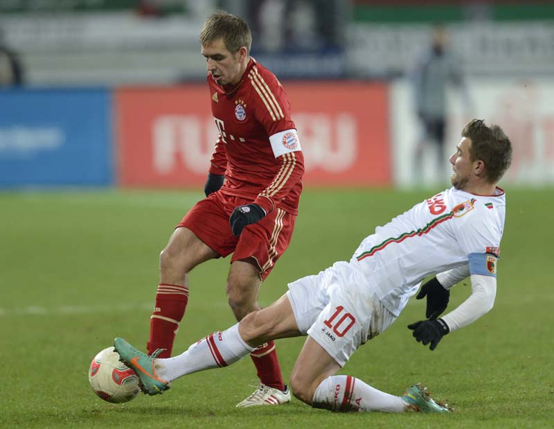 Philipp Lahm, do Bayern (à espquerda) e o meio campo Daniel Baier, do Augsburg | AFP PHOTO/CHRISTOF STACHE