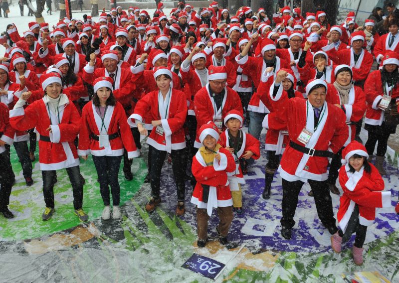 Aproximadamente 200 pessoas - vestidas de Papai Noel - dançam o "Gangnam style" | AFP PHOTO / KIM JAE-HWAN