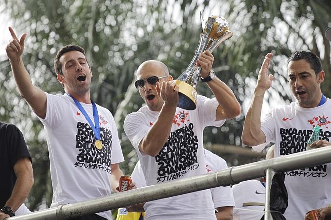 Capitão Alessandro com o troféu de campeão mundial, entre o dirigente Edu Gaspar e Chicão | 