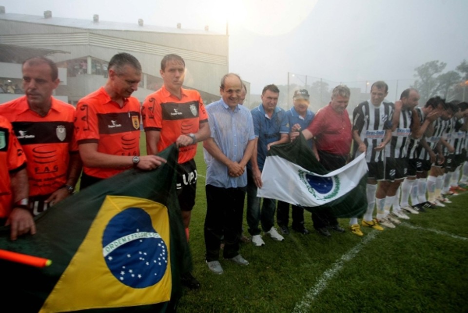 Suburbano até debaixo d´água: Além de ir ao estádio do Trieste para acompanhar a decisão da Suburbana, campeonato amador de futebol de Curitiba, Gustavo Fruet mostrou que veste a camisa da cidade em qualquer clima. O prefeito eleito ficou firme ao lado dos times, sábado à tarde, para cantar o Hino Nacional, quando a forte chuva surpreendeu, ensopando tudo e todos. A partida entre Bairro Alto (time do bairro onde nasceu e cresceu a esposa de Fruet, Márcia) e Iguaçu teve que ser adiada por causa do toró que alagou o campo | Jader da Rocha