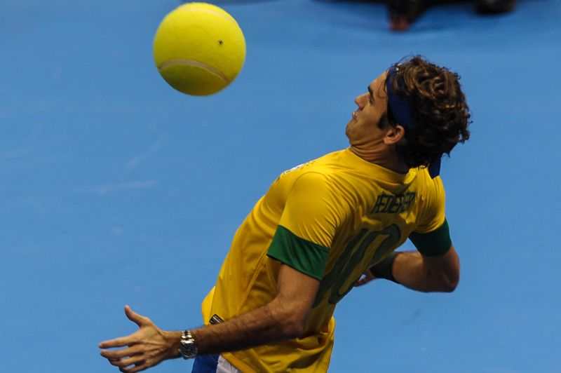 Roger Federer, usando a camisa do Brasil, controla uma bola de tênis gigante durante último jogo do Gillette Federer Tour, em São Paulo | AFP PHOTO/Yasuyoshi CHIBA