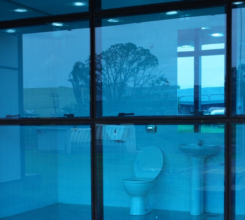 Imagem mostra um dos banheiros do prédio antes de passar pela aplicação da película nos vidros | José Aldinan/Gazeta do Povo