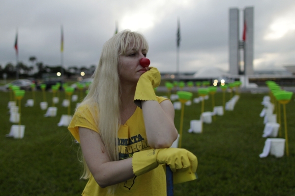 Manifestantes fazem faxina em frente do Congresso: Cerca de 20 manifestantes fizeram ontem um protesto no gramado em frente do Congresso Nacional contra a candidatura de Renan Calheiros (PMDB-AL) à presidência do Senado. Impedidos pela segurança do Congresso de lavarem a rampa numa faxina para limpeza da Casa, os manifestantes fizeram a lavagem simbólica no lago em frente à sede do Legislativo. O grupo desenhou uma cruz no gramado principal formada com baldes e vassouras. O gesto, segundo o coordenador do movimento e presidente da ONG Rio de Paz, Antônio Carlos Costa, representa a necessidade do Senado limpar sua imagem, elegendo um candidato ficha limpa para o comando da instituição. A ONG é responsável por recolher assinaturas, em uma petição eletrônica, contra a candidatura de Renan, que já soma o apoio de mais de 80 mil pessoas | Ueslei Marcelino/Reuters