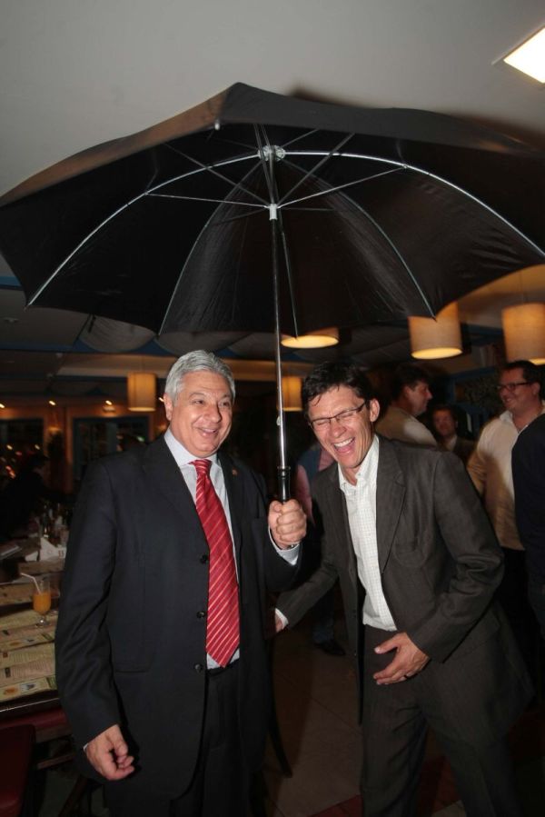 O novo presidente da Câmara Municipal de Curitiba, Paulo Salamuni (à esq.), e o líder do governo, Pedro Paulo, no jantar para comemorar a eleição da nova mesa diretora da Casa anteontem, no restaurante Quintal do Guima. Os dois aceitaram a sugestão do fotógrafo para simular que estão protegidos das intempéries políticas que assolaram o Legislativo curitibano no ano passado | Jader da Rocha