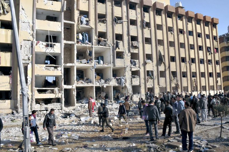 Membros de equipes de resgate e moradores de Aleppo procuram vítimas em prédio universitário onde ocorreu explosão. | George Ourfalian/Reuters
