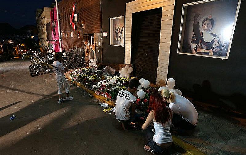 Flores e cartazes foram colocados na fachada da boate Kiss, em Santa Maria, para lembrar as vítimas do incêndio | EFE/Marcelo Sayão