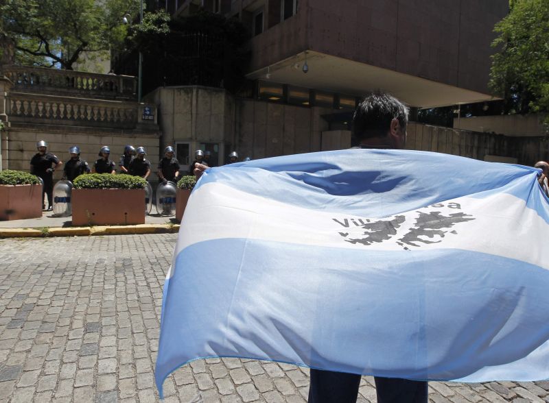 Veterano da Guerra das Malvinas veste uma bandeira argentina com o mapa das ilhas, durante protesto diante da embaixada britânica, em Buenos Aires | Enrique Marcarian/Reuters