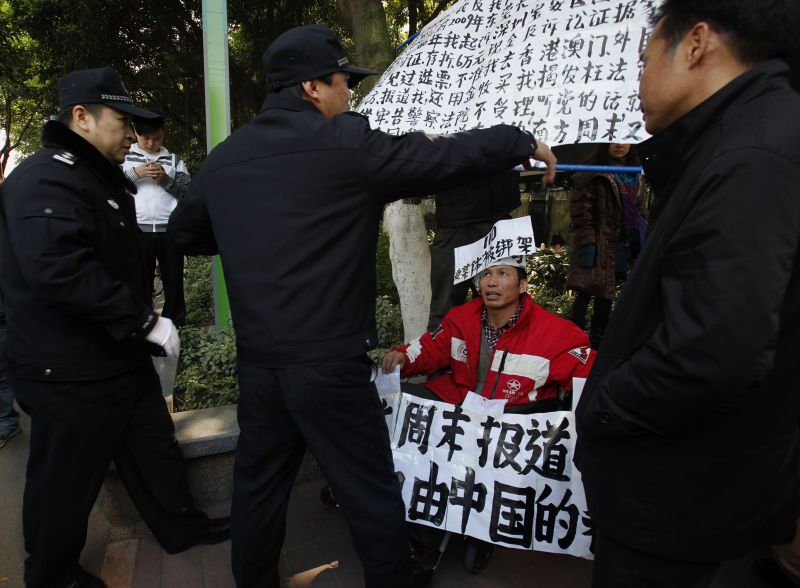 Manifestante protesta contra a censura na China e policiais tentam impedir o ato | REUTERS/Bobby Yip