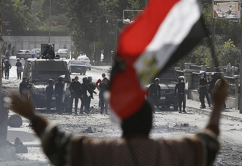 Manifestante segura a bandeira egípcia enquanto é observado por forças de segurança no Cairo | REUTERS/Amr Abdallah Dalsh