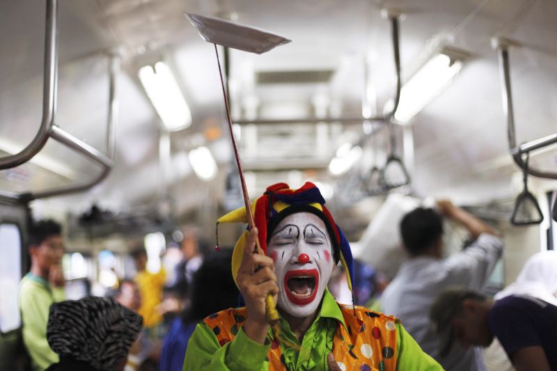 O palhaço indonésio Andri Hendri faz uma performance no metrô de Jacarta, divertindo os passageiros | REUTERS/Beawiharta