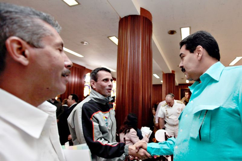 O vice Nicolás Maduro (direita) se encontra com o rival de Chávez, o líder opositor Henrique Capriles (centro) | Presidência da Venezuela/EFE
