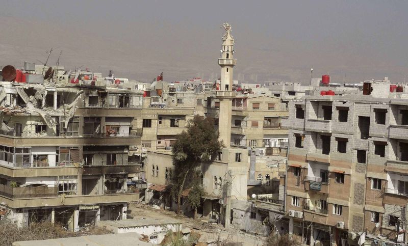 Imagem distribuída pela agência de notícias Sana mostra prédios danificados pelos conflitos de ontem, perto de Damasco | Sana Handout/Reuters