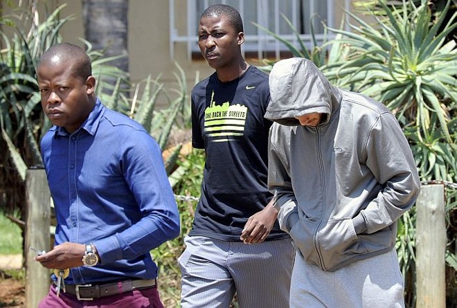 Oscar Pistorius é escoltado por policiais após o assassinato de sua namorada, Reeva Steenkamp | 