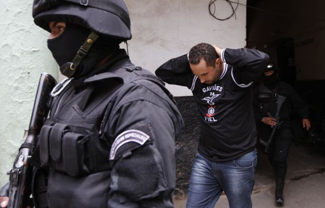 Torcedor corintiano é acompanhado pela polícia. Doze foram indiciados por homicídio - dois diretamente e dez como cúmplices |