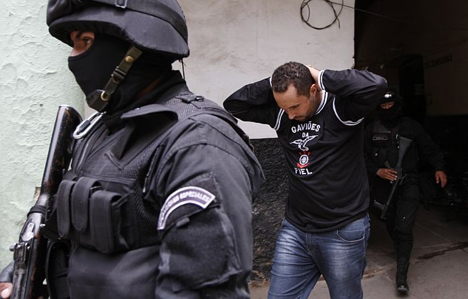 Um dos 12 corintianos suspeitos de atirarem o sinalizador que vitimou torcedor boliviano é escoltado pela polícia | Juan Karita / AP