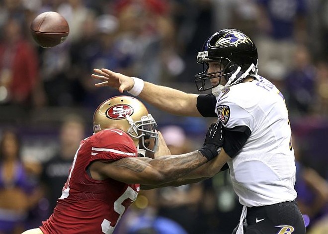 Quarterback do Ravens Joe Flacco lança a bola marcado por Navorro Bowman, do 49ers |