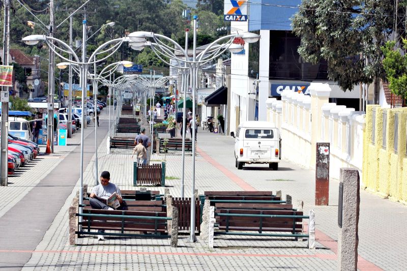 Sequência de postes e bancos em Piraquara: sem árvores para sombra, leitura é ao sol | André Rodrigues/Gazeta do Povo