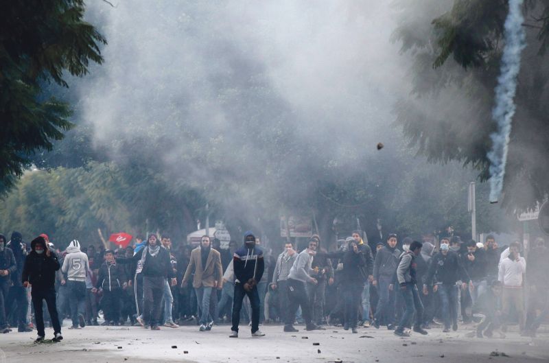 Manifestantes enfrentam a polícia em Túnis: milhares de pessoas entoaram dizeres anti-islâmicos no funeral de Belaid | Anis Mili/Reuters