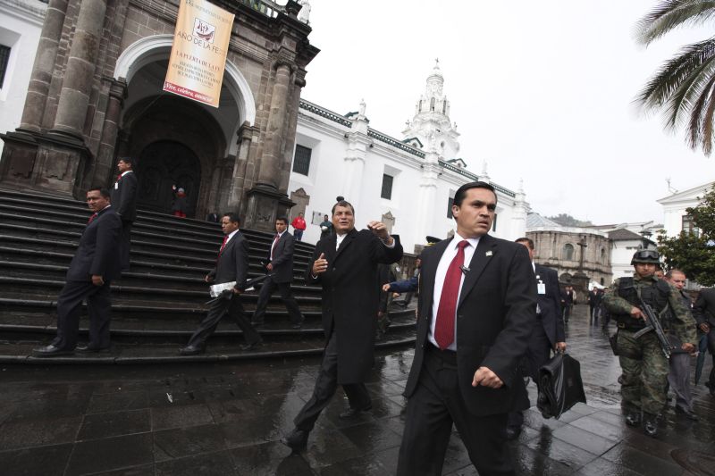 Rafael Correa é escoltado por seguranças, em Quito | Gary Granja/Reuters