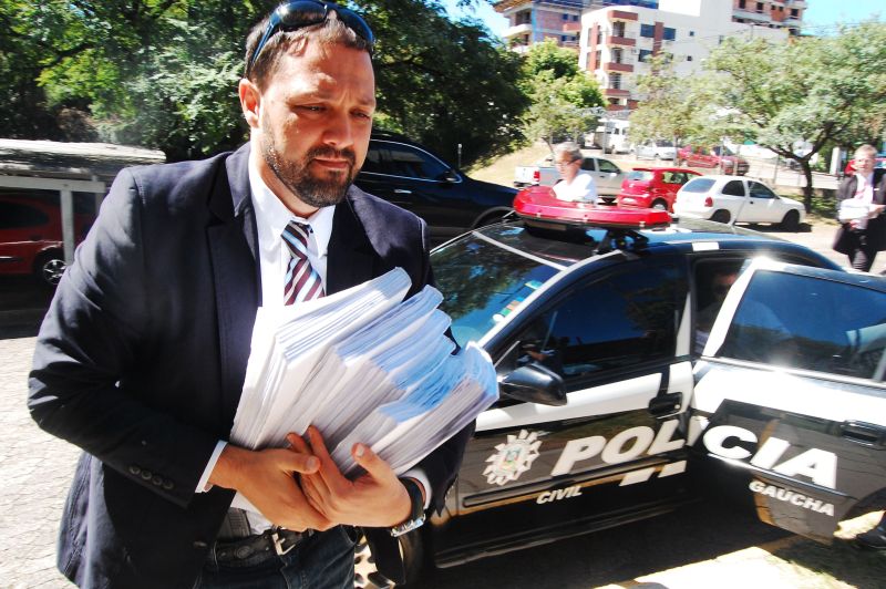 Delegado Marcelo Arigony, responsável pela investigação, carrega volumes do inquérito, que soma 13 mil páginas | Eduardo Ramos/Folhapress