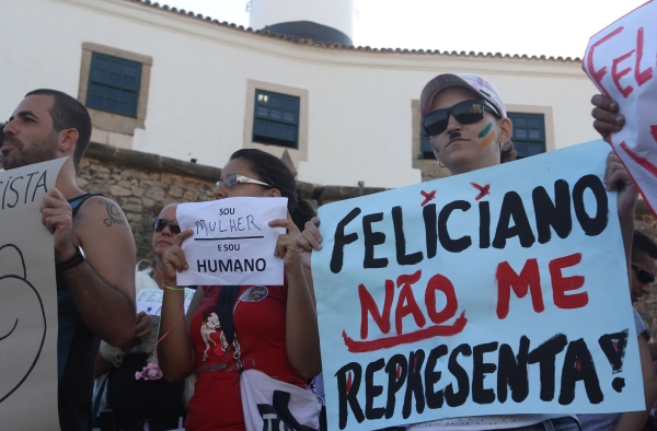 Redes sociais mobilizam protestos: Em São Paulo, Rio de Janeiro, Curitiba, Brasília e Salvador, populares protestaram, durante o fim de semana, contra a eleição do pastor Marco Feliciano (PSC-SP) para a presidência da Comissão de Direitos Humanos da Câmara dos Deputados. Na Avenida Paulista, 600 pessoas participaram do ato de repúdio no sábado. No mesmo dia, em Curitiba, a concentração foi na Praça Santos Andrade. Soteropolitanos se encontraram no Farol da Barra (foto), no domingo. O protesto foi organizado pelas redes sociais, por militantes de direitos humanos, ativistas pelos direitos de gays e negros. Em algumas cidades, manifestações contra-Feliciano se encontraram com protestos pela saída de Renan Calheiros da presidência do Senado | Leogump Carvalho/Frame/Folhapress