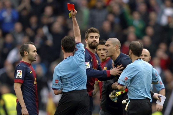 O árbitro Pérez Lasa, sob protestos, mostra o cartão vermelho para o goleiro catalão Vítor Valdés |