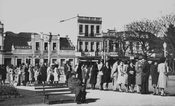 Passageiros esperam pacientemente, como bons curitibanos, em fila para tomarem o ônibus, na Praça Tiradentes, que os levaria para o bairro. Foto de 28 de agosto de 1946 | Acervo Cid Destefani