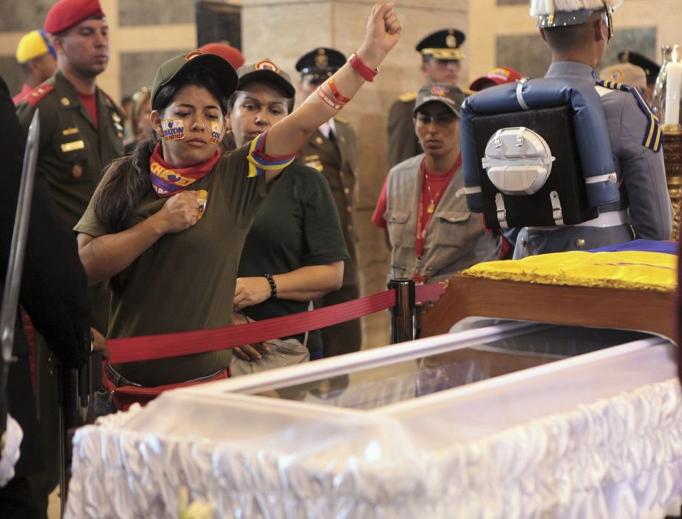 Jovem faz saudação ao passar pelo corpo do presidente venezuelano, Hugo Chávez | REUTERS/Palácio Miraflores/Divulgação
