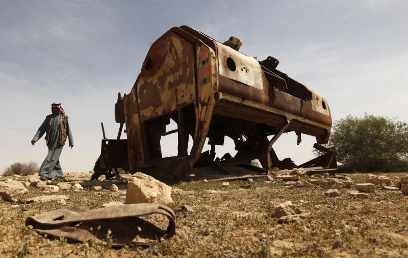 Iraquiano caminha perto do que moradores de Samawa, a 270 km de Bagdá, dizem ser um veículo norte-americano destruído durante a Guerra do Iraque, que completou 10 anos na última quarta | Mohammed Ameen/Reuters