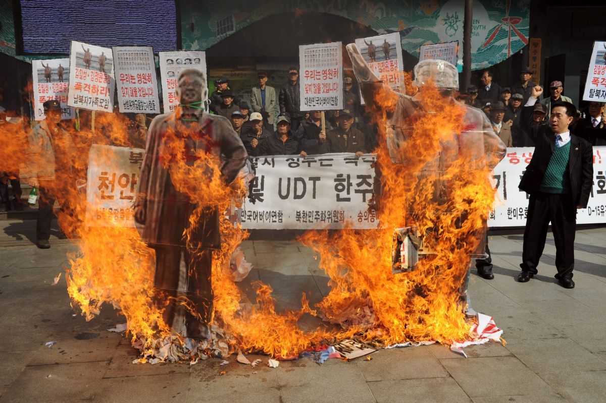 Ativistas sul-coreanos queimam imagens dos ex-líderes norte-coreanos Kim Il-Sung e Kim Jong-Il | EFE/Lee Jun-Sang