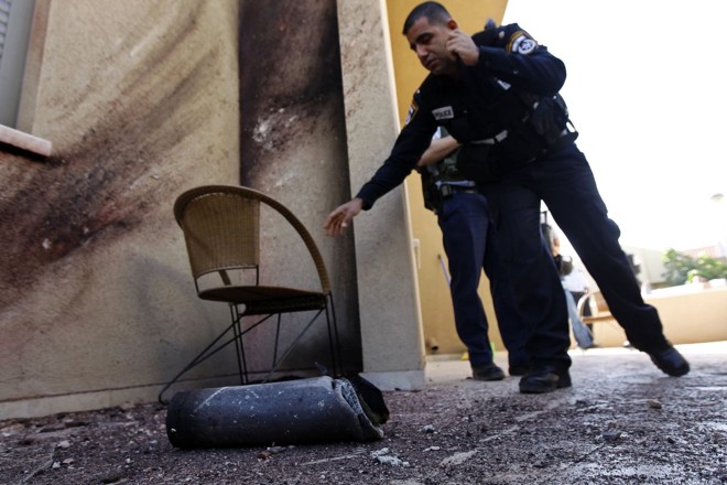 Policiais israelenses inspecionam os restos de um foguete palestino disparado contra a cidade de Sderot | Reuters/Amir Cohen