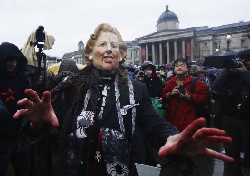 Manifestante usa máscara com rosto da ex-primeira-ministra durante o protesto, no centro de Londres. | REUTERS/Olivia Harris