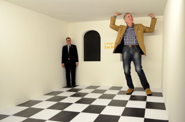 O secretário da Cultura do estado, Paulino Viapiana, sentiu-se, por alguns instantes, um gigante ao entrar em uma das instalações interativas que constam da exposição A magia de Escher, aberta na noite de quarta-feira no Museu Oscar Niemeyer. Ele e o curador da mostra, Pieter Tjabbes (à esq.), posaram na Sala da Relatividade, que proporciona ao espectador um incrível efeito de ilusão de ótica | Kraw Penas/SEEC