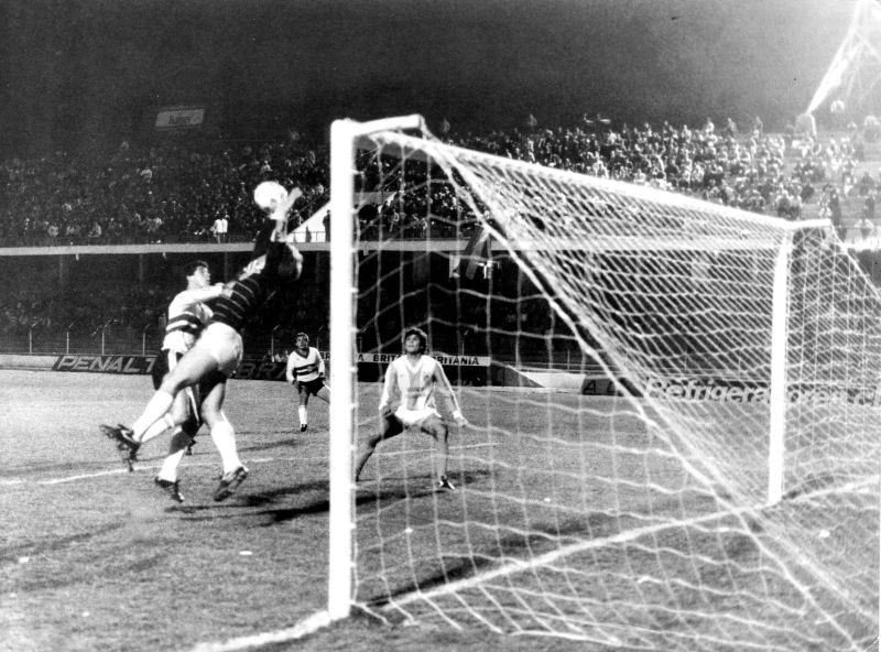 Zetti, que na época ainda usava shorts, defende no alto sob pressão de Marildo. Edson (ao fundo) seguiu o lance | Arquivo/ Gazeta do Povo