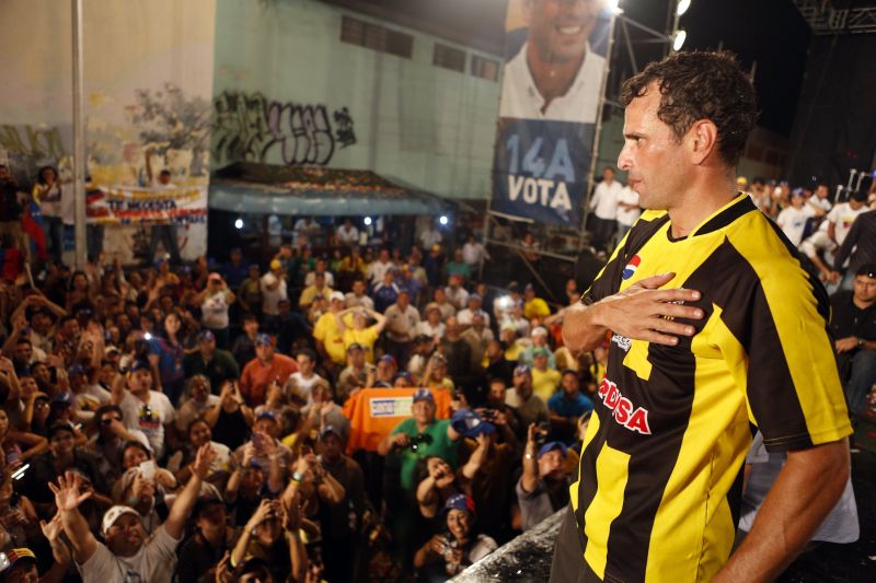 Candidato oposicionista à presidência da Venezuela, Henrique Capriles cumprimenta eleitores durante comício em um reduto histórico chavista, no centro de Caracas, neste domingo (7) | Reuters/Carlos Garcia Rawlins