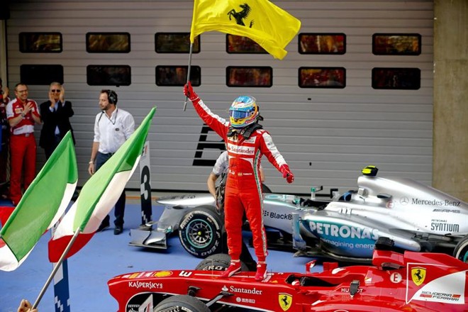 Alonso comemora vitória com a bandeira da escuderia |
