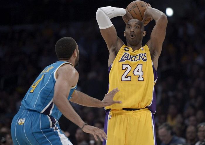 Kobe Bryant prepara a jogada, marcado por Xavier Henry, na vitória do Lakers sobre o Hornets | Paul Buck / EFE