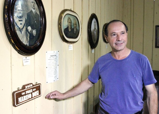 O pesquisador Arnoldo Bach mostra fotos de membros da Colônia Cecília |