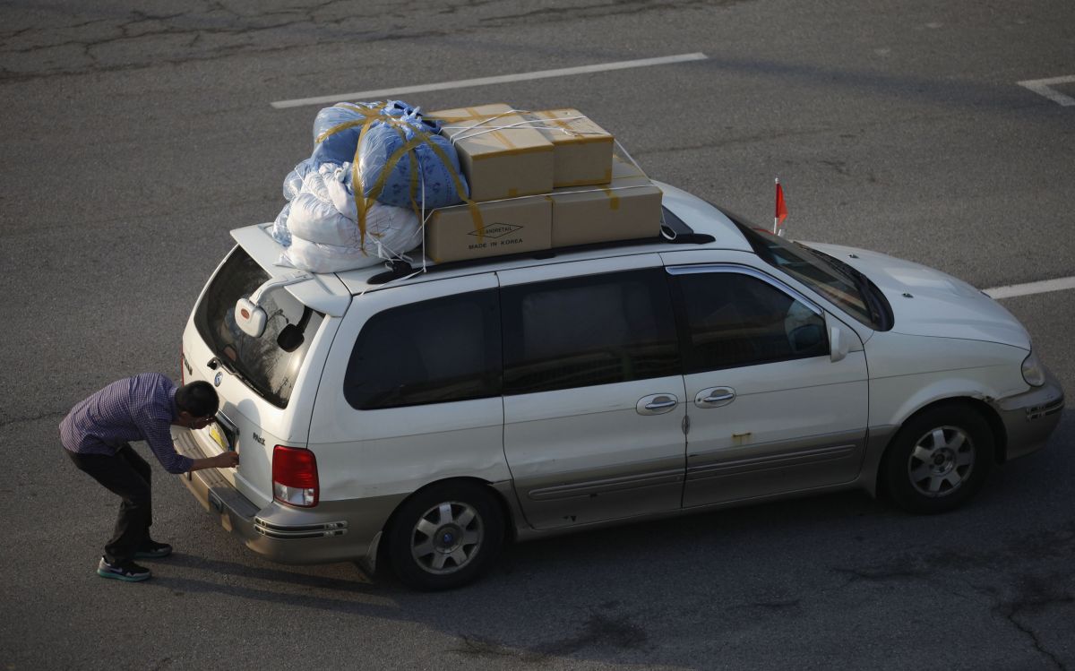Trabalhador sul-coreano do complexo de Kaesong troca a placa de seu veículo para atravessar do Norte para o Sul | Reuters/Kim Hong-Ji