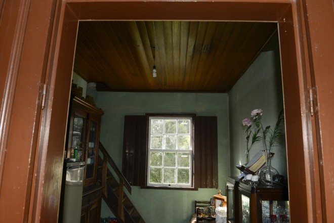 Detalhe do interior da casa mostra a madeira bem conservada nas portas, janelas, piso e escada para o sótão |