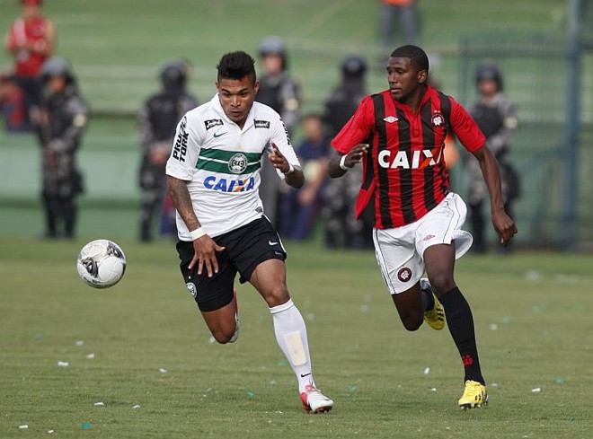 Uma das surpresas da escalação do Coxa, o volante Júnior Urso disputa a bola com o atacante Douglas Coutinho | 