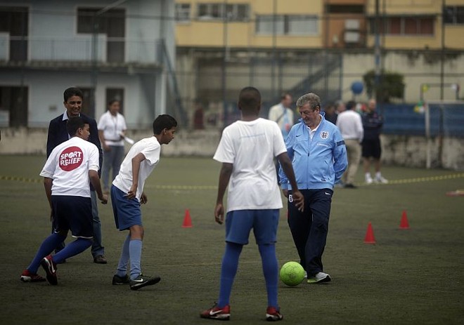 Observado por Bebeto, o técnico da seleção inglesa, Roy Hodgson, bate bola com crianças do Instituto Bola Pra Frente, no Rio | Ricardo Moraes / Reuters