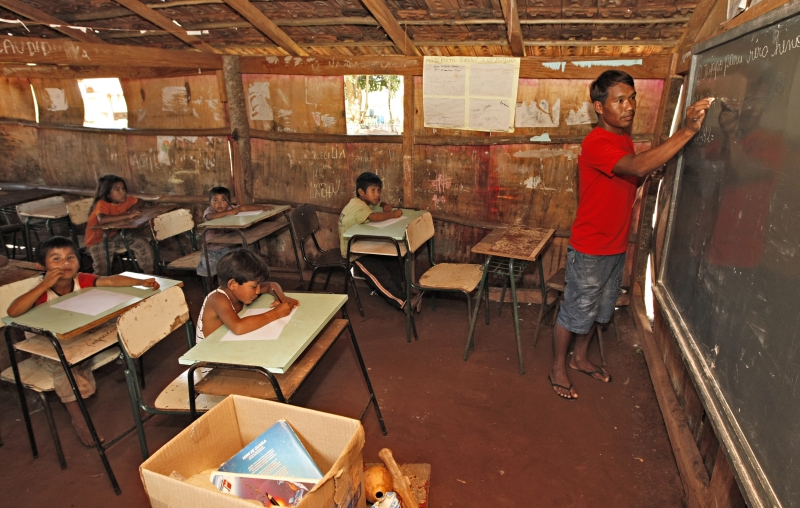 Crianças assistem à aula na aldeia Tekoha Hevy, na área rural de Guaíra: índios vivem sem trabalho, comida e moradia digna | Christian Rizzi / Gazeta do Povo