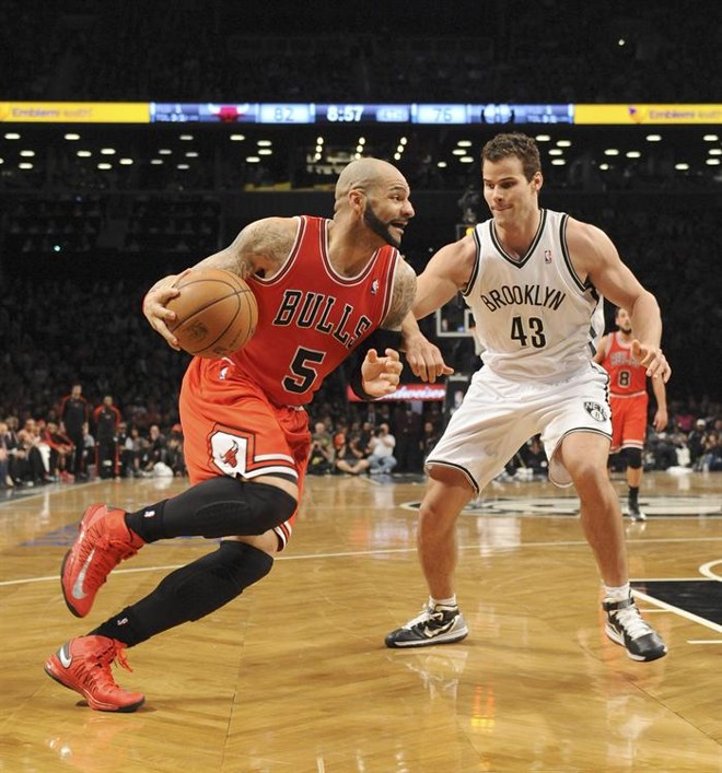 Carlos Boozer (à esquerda), do Chicago Bulls, chega a àrea do Brooklyn Net e enfrenta a defesa de Chris Humphries (à direita) | 