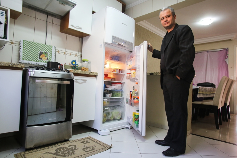 Jucimar, com a geladeira comprada pelos filhos: bronca por não conseguir pagar o presente | Brunno Covello/ Gazeta do Povo