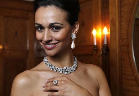 Modelo veste colar de diamante da Bulgari (1954), par de brincos com pingente de diamente e pérola (1962) e anel de diamante (1962) durante prévia do leilão na casa Sothebys | REUTERS/Denis Balibouse