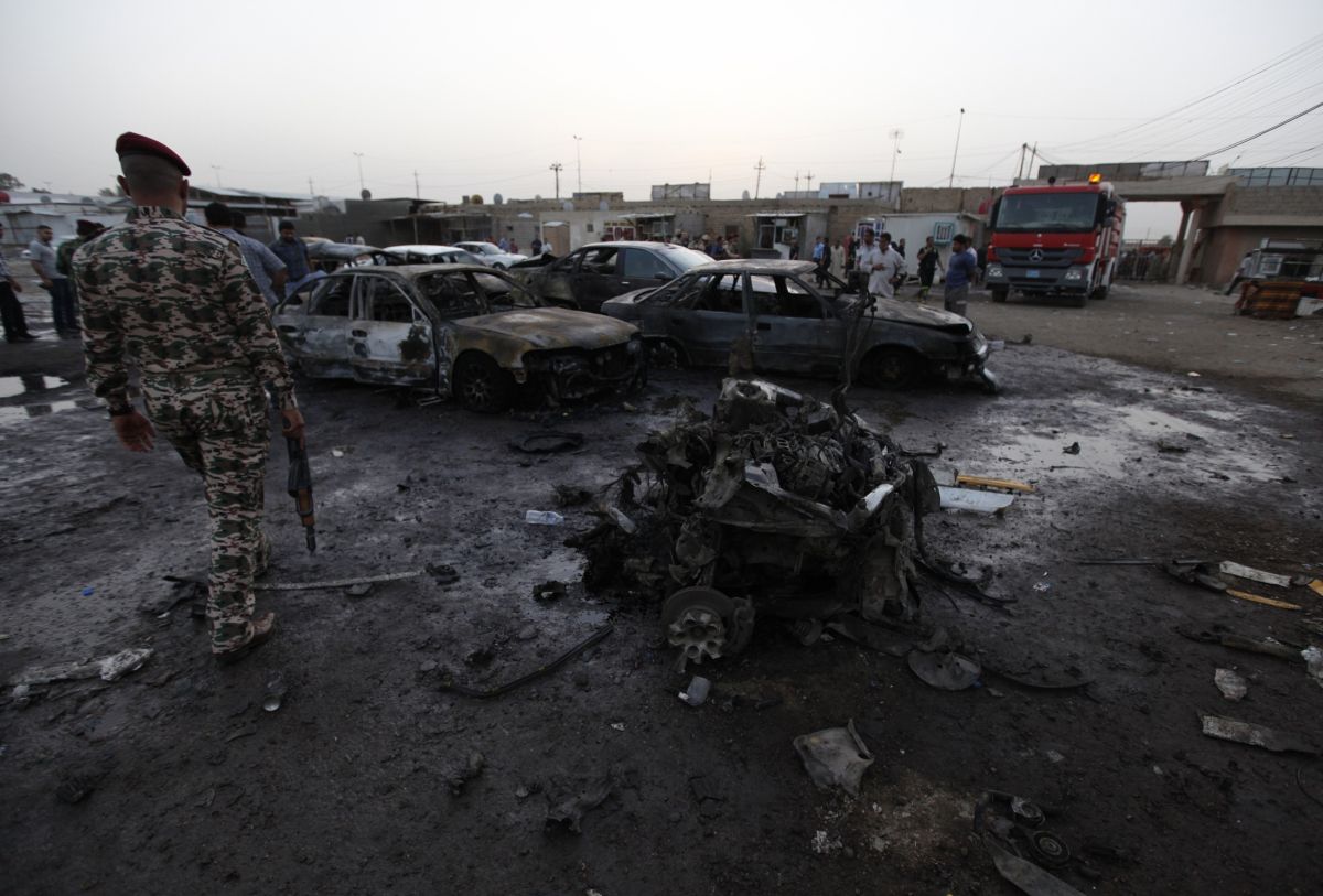 Soldado observa os destroços de um carro-bomba usado nos ataques | Reuters/Thaier al-Sudani